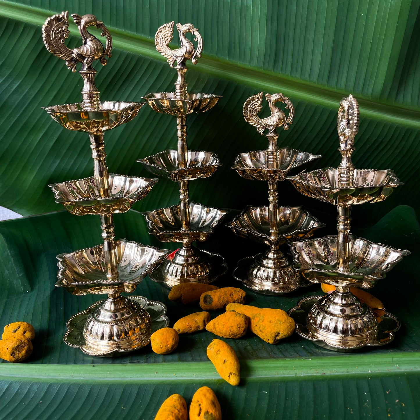Set of silver metal lamps with decorative top on a green leaf background